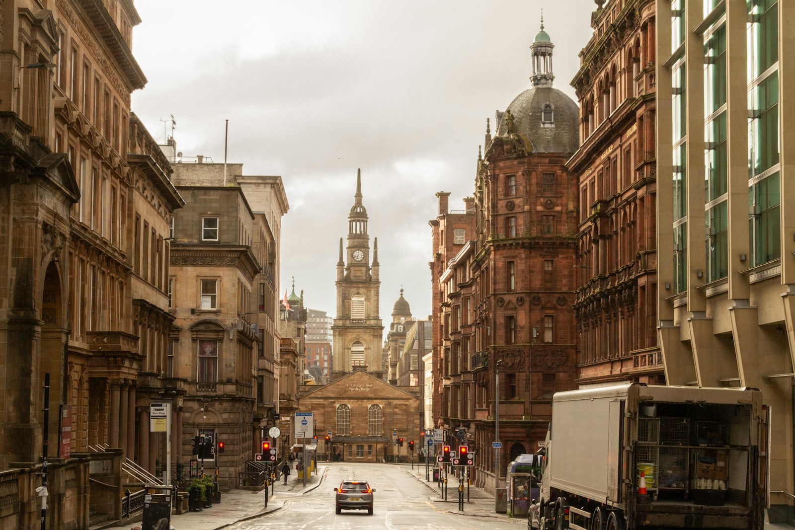 A truck is driving down a narrow city street