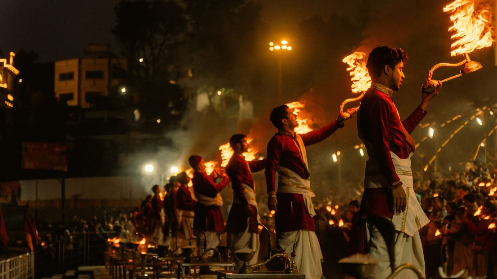 Captivating Ganga Aarti ceremony in Rishikesh, India with priests holding flaming torches.